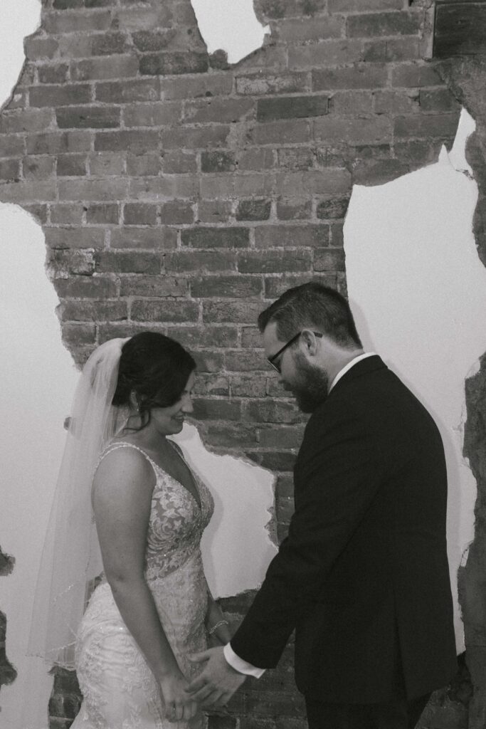 Bride and groom embracing during their first look, with joyful smiles and candid emotion.