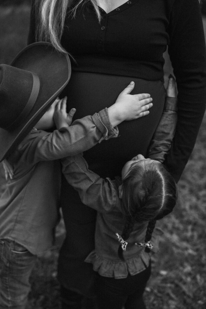 Family celebrating their upcoming baby during a fall maternity session outdoors in Missouri with warm autumn colors and western-inspired styling