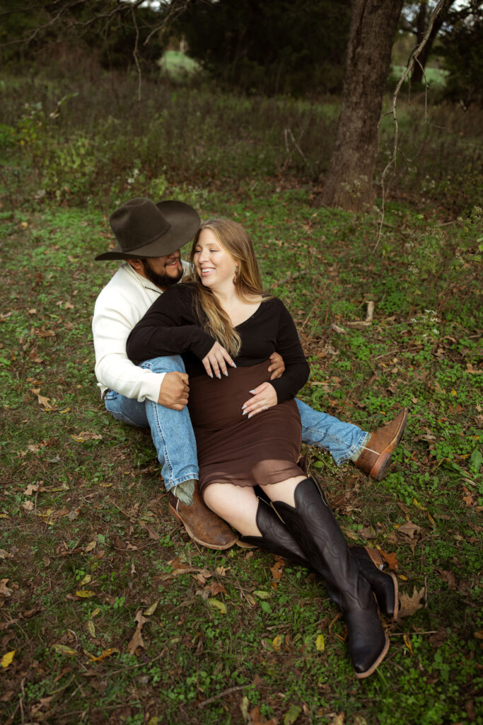 Family celebrating their upcoming baby during a fall maternity session outdoors in Missouri with warm autumn colors and western-inspired styling