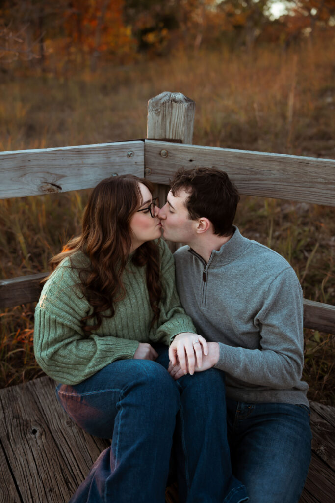 Engaged couple sharing a romantic moment among vibrant fall foliage at Ha Ha Tonka State Park in Missouri