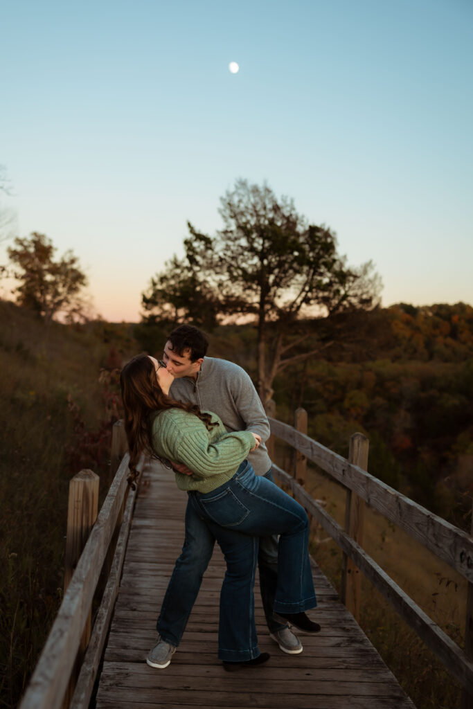 Engaged couple sharing a romantic moment among vibrant fall foliage at Ha Ha Tonka State Park in Missouri
