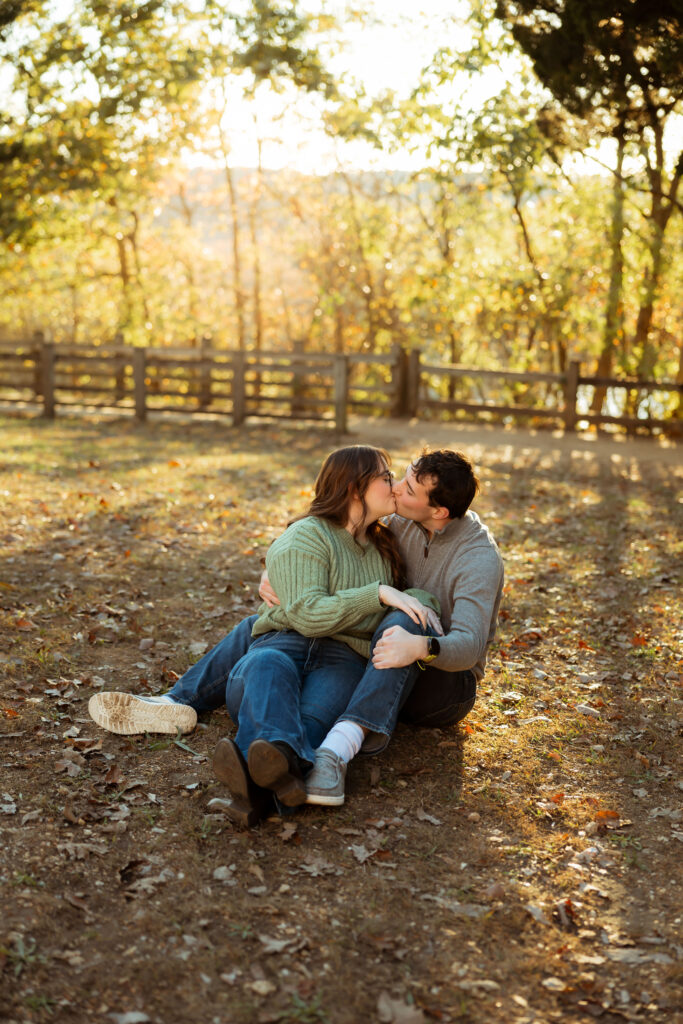 Engaged couple sharing a romantic moment among vibrant fall foliage at Ha Ha Tonka State Park in Missouri