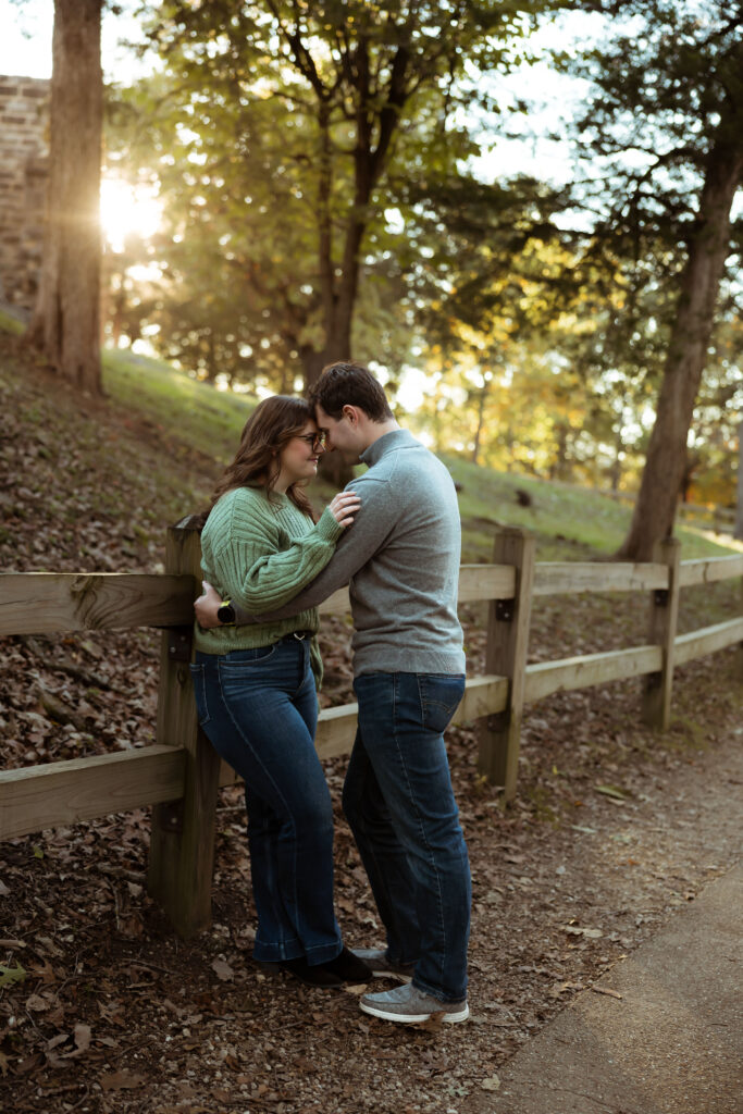 Engaged couple sharing a romantic moment among vibrant fall foliage at Ha Ha Tonka State Park in Missouri