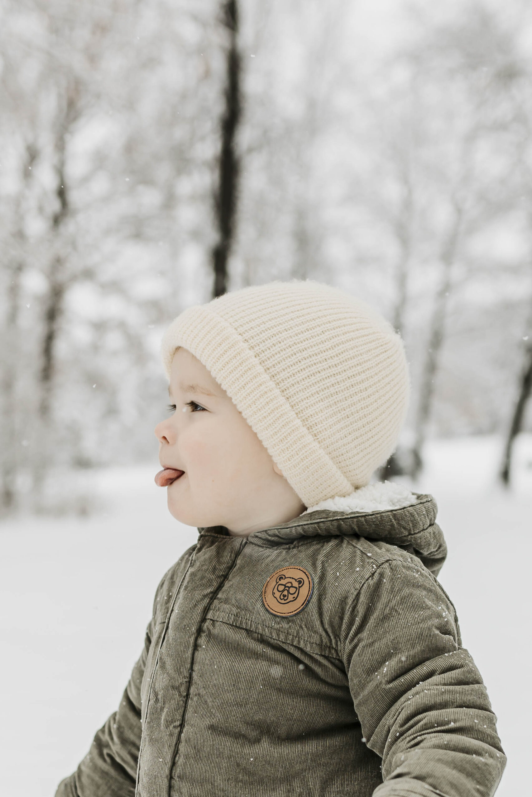 Documentary-style winter photo of a toddler experiencing snow for the first time