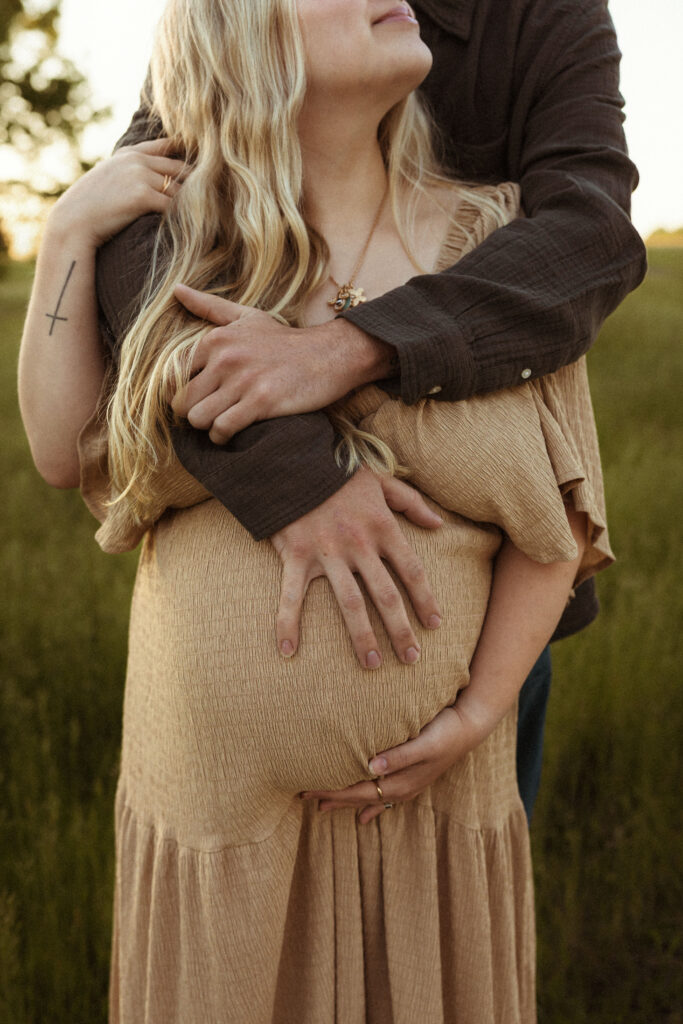 Close-up maternity photo from outdoor Missouri session highlighting baby bump, natural light, and earthy film-inspired photography style.