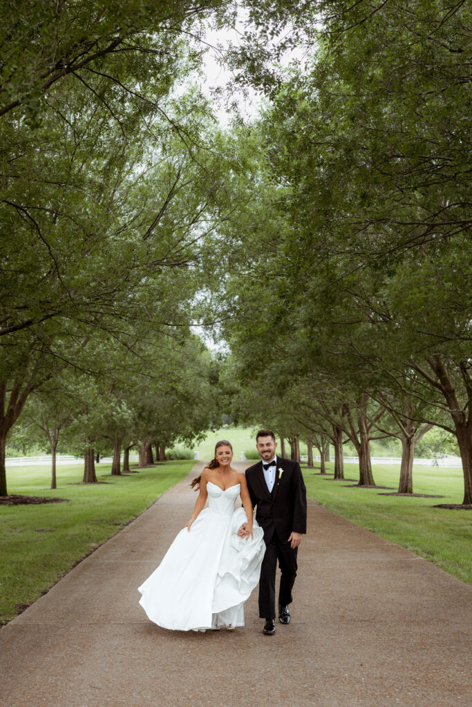 Newlywed couple portrait on the tree-lined driveway at The Callaway Jewel wedding venue in Fulton, Missouri